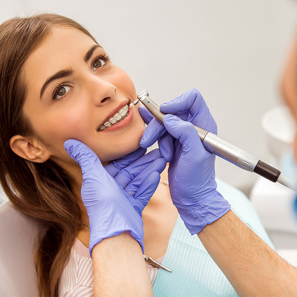 A beautiful girl realigning her braces to the dentist.