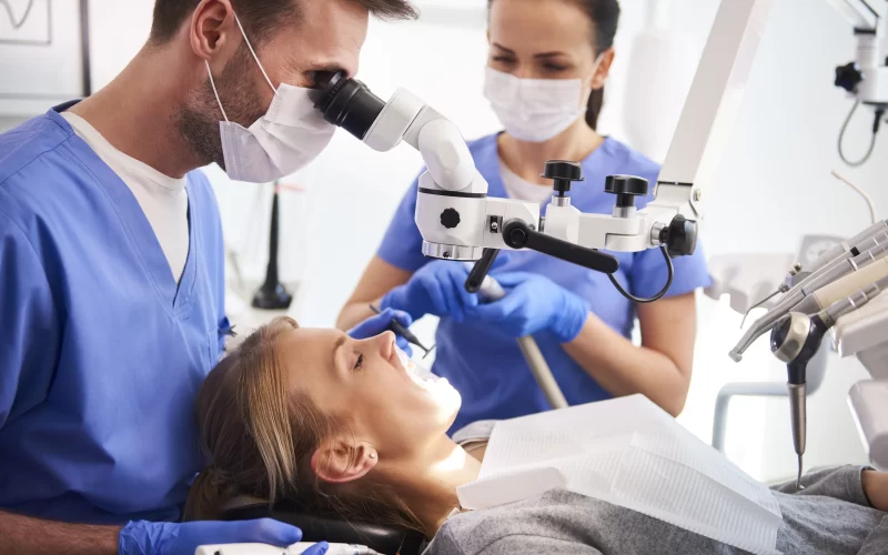 A dentist and his assistant performing a root canal service procedure